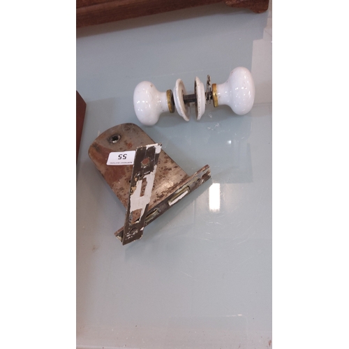 55 - Victorian-style white ceramic door knob set with brass collars and iron spindle, accompanied by a mo... 