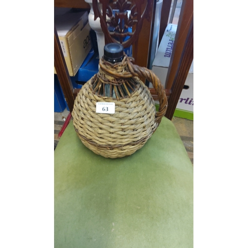 63 - Wicker-covered glass demijohn, with braided swing handle and tapering neck fitted with a screw cap; ... 