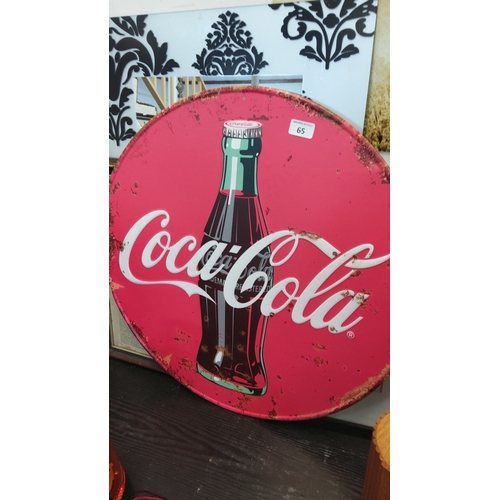 65 - Coca-Cola—circular tin advertising sign, printed in red with the classic script logo and a central s... 