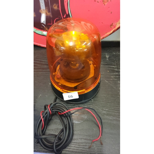 66 - Rotating amber warning beacon light, the translucent plastic dome over a motorised reflector, on a b... 