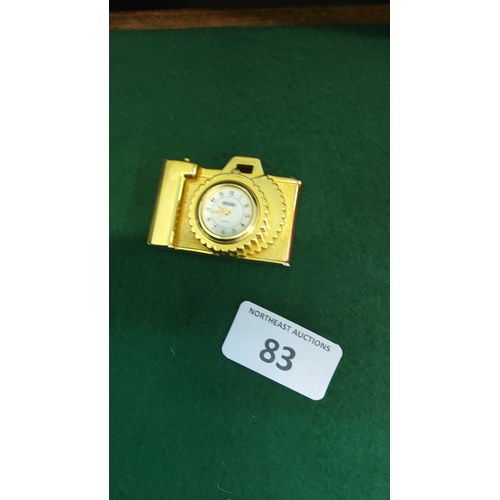 83 - Gold-tone camera-form miniature novelty quartz desk clock, with Arabic numeral dial within a scallop... 