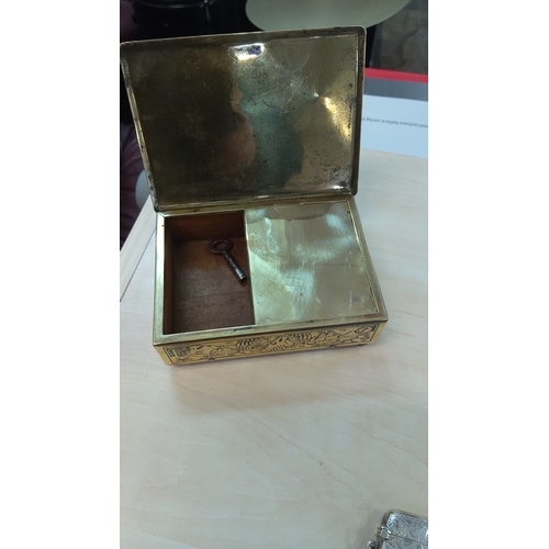 97 - Brass musical box of rectangular form, the hinged lid chased with a river landscape with junk, pagod... 