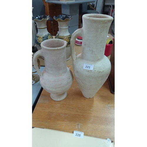 221 - A pair of pottery ewers, each of baluster form with strap handle and broad mouth, the surfaces left ... 