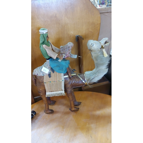 230 - Decorative leather camel model with articulated legs, covered in brown hide, with raffia saddle blan... 