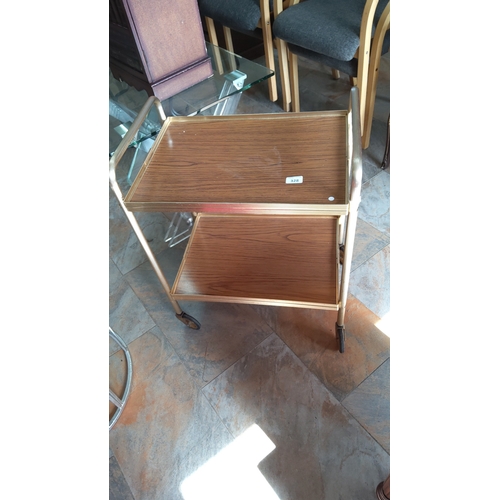 328 - Mid-20th century two-tier tea trolley with faux wood-grain laminate trays within a gilt-metal tubula... 