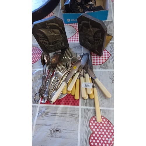 385 - A mixed group of flatware including stainless-steel forks and spoons, a collection of table knives w... 