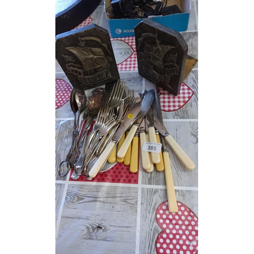 385 - A mixed group of flatware including stainless-steel forks and spoons, a collection of table knives w... 