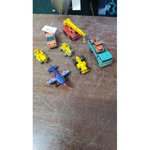 412 - A group of die-cast toy vehicles and models including a crane lorry, flatbed truck with load, saloon... 