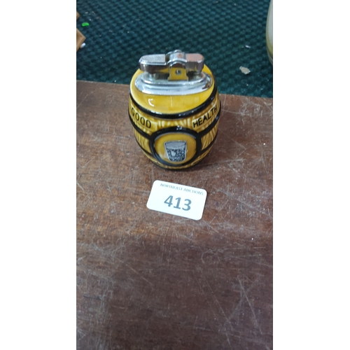 413 - Irish sloganware ceramic table lighter, of barrel form with yellow glaze and black banded decoration... 