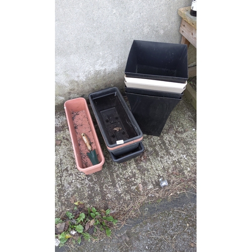 499 - An assortment of plastic garden planters, including tall square tapered planters in black and white,... 
