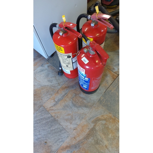 502 - A group of portable fire extinguishers, red-painted cylinders with lever handles, pressure gauges, h... 