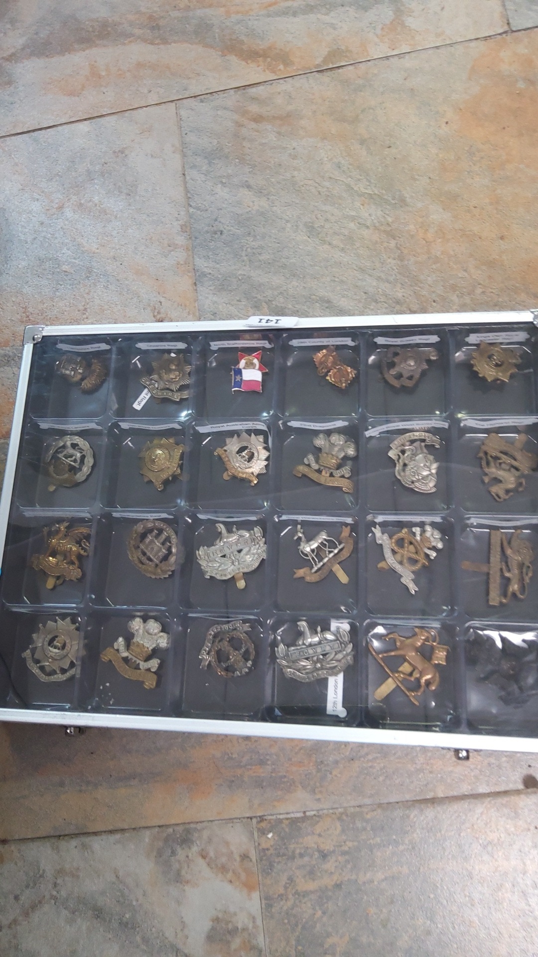 A collection of military cap badges and insignia in brass, white metal ...