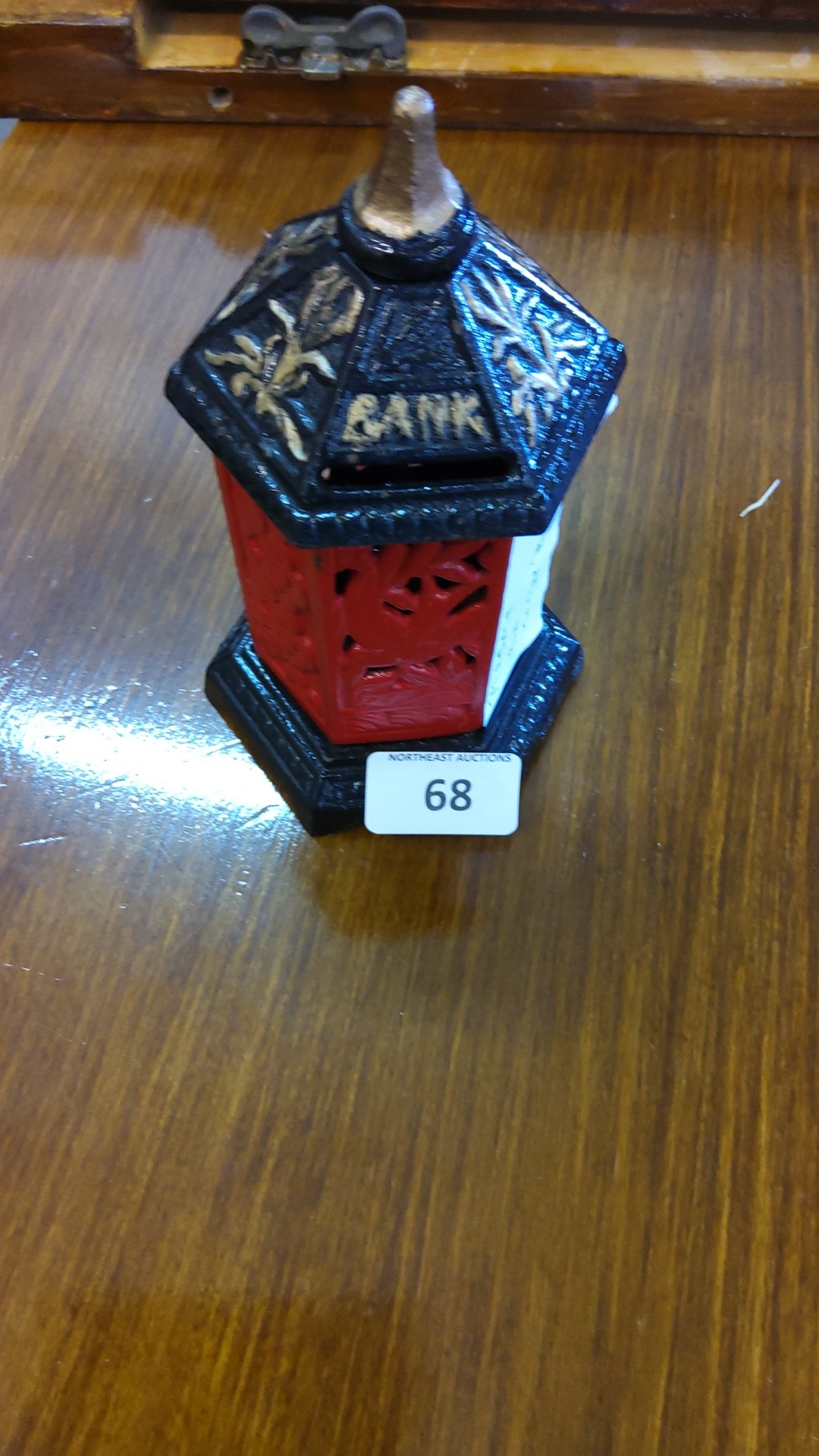 Pagoda-form cast-iron money box, painted red and black with gilt floral ...