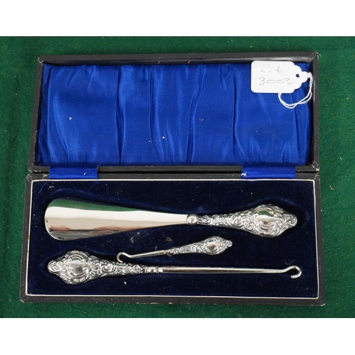 82 - Boxed set of hallmarked silver button hooks and shoe horn