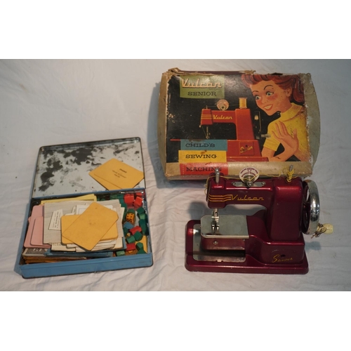 751 - Vulcan Senior childs sewing machine in box and tin of Monopoly money, pieces etc