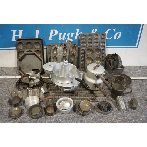 64 - Assorted kitchen tinware to include jelly moulds, cooking trays, cutters, saucepans, pie tins etc