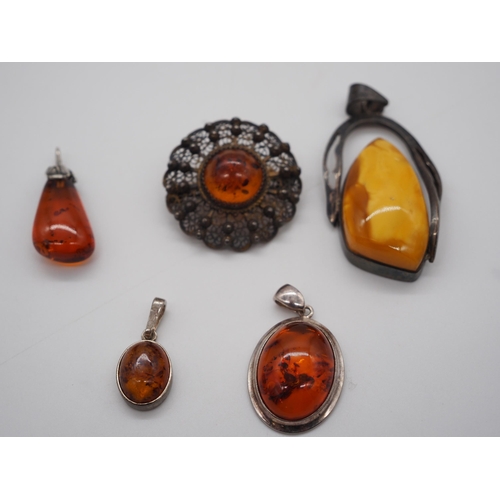 319 - Assorted silver and amber pendants and brooches