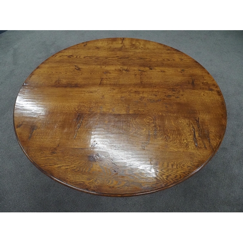 72 - Oak circular top dining table supported by a turned column and 3 swept legs 59