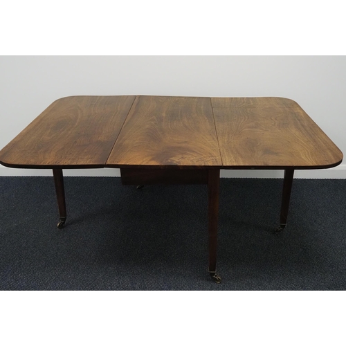 84 - Mahogany drop leaf dining table with a knuckle hinge and on brass casters 40