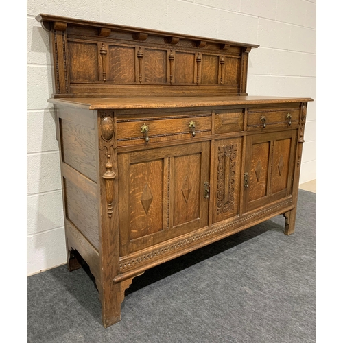 242 - Oak carved sideboard with brass drop handles, drawers, cupboards and keys 53