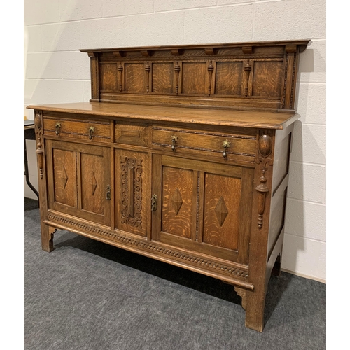 242 - Oak carved sideboard with brass drop handles, drawers, cupboards and keys 53