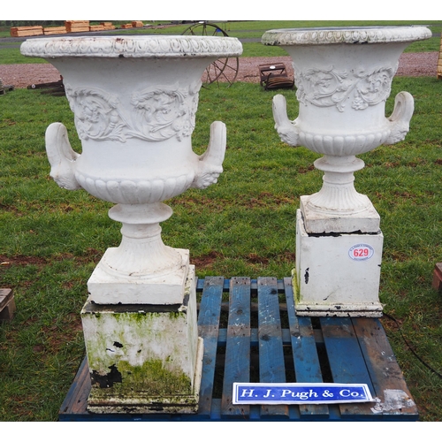 Pair of large stone urns on plinths