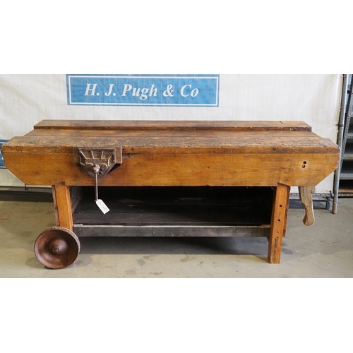 606 - Wooded work bench with vice and on cast wheels 7ft