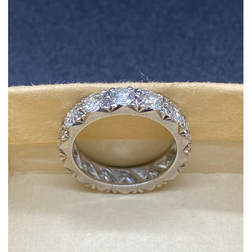 200A - A precious white metal diamond eternity ring, grain set 14 round brilliant-cut diamonds in carved a ... 