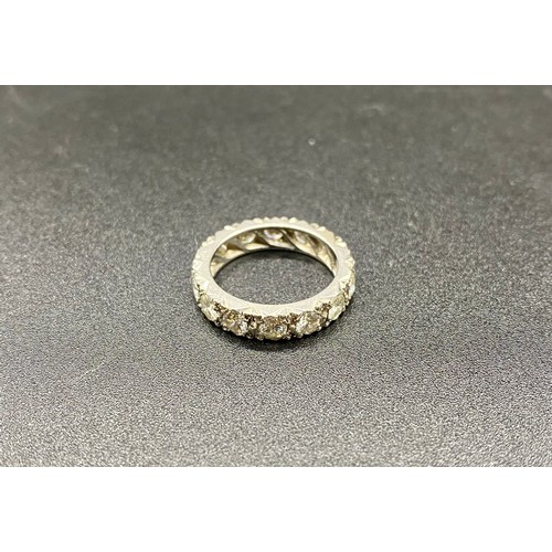 200A - A precious white metal diamond eternity ring, grain set 14 round brilliant-cut diamonds in carved a ... 