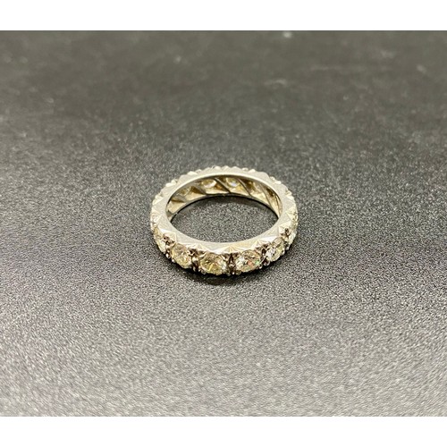 200A - A precious white metal diamond eternity ring, grain set 14 round brilliant-cut diamonds in carved a ... 