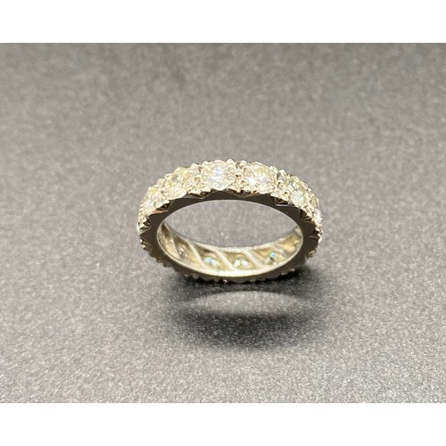 200A - A precious white metal diamond eternity ring, grain set 14 round brilliant-cut diamonds in carved a ... 