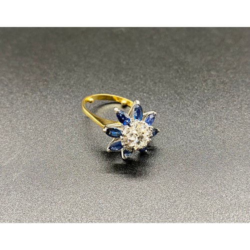 200B - A yellow gold sapphire and diamond cluster ring. Claw set central round brilliant-cut within a borde... 