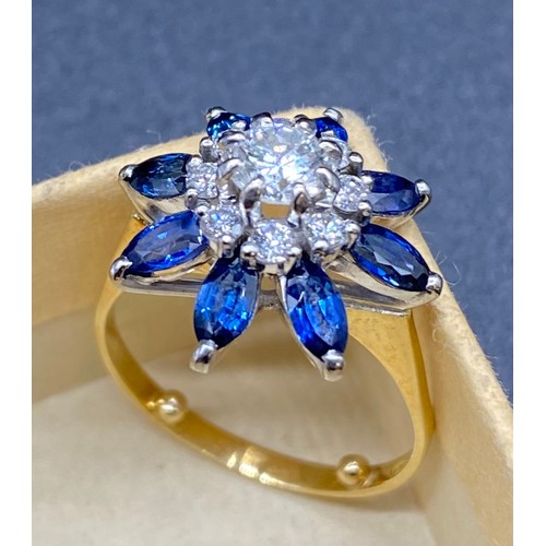 200B - A yellow gold sapphire and diamond cluster ring. Claw set central round brilliant-cut within a borde... 