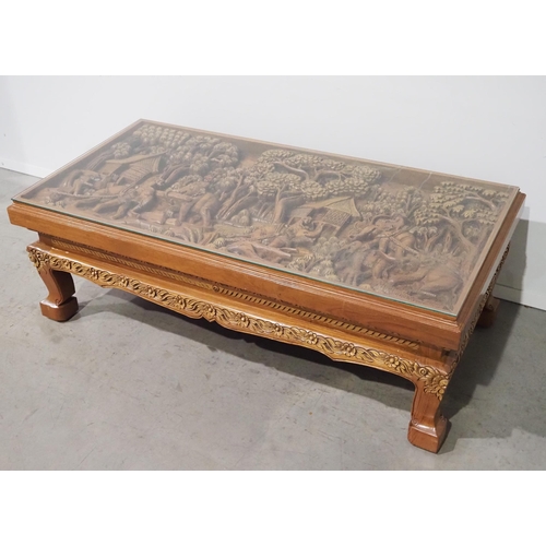 829A - Heavily carved coffee table with glass top depicting elephants in the jungle H17