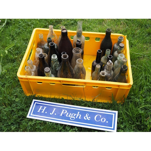 22 - Yellow box containing 38 glass bottles with trade name details embossed