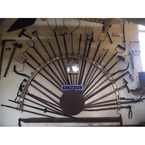 77 - Various early hand tools displayed on rack