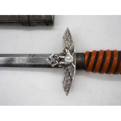 37 - WW2 German Officer's Dress Dagger. With an orange grip, featuring a detailed pommel with Swastika em... 