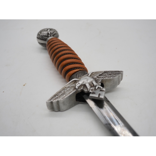 37 - WW2 German Officer's Dress Dagger. With an orange grip, featuring a detailed pommel with Swastika em... 