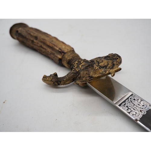 42 - German Hunting Dagger With Antler Horn Grip. Featuring a decorative pommel and cross guard with dog ... 