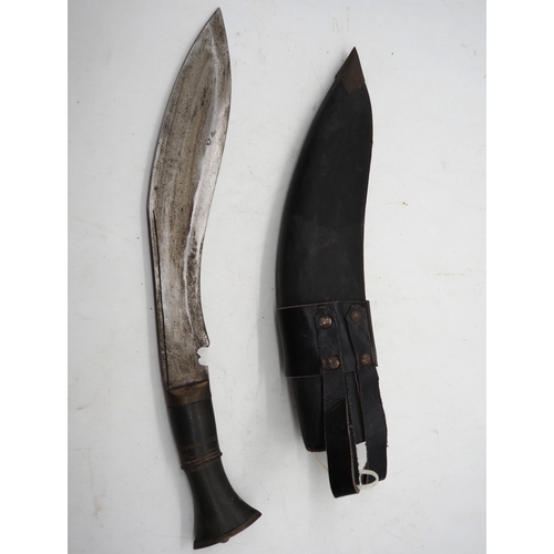 53 - Nepalese Ghurkha Knife. With a dark wooden grip, single edged blade complete with leather scabbard w... 