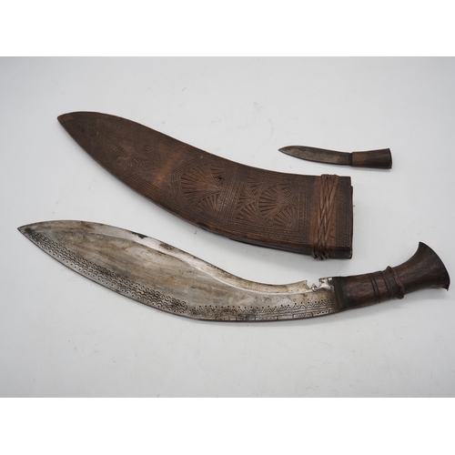 54 - Nepalese Ghurkha Knife. Carved wooden handle complete with carved wooden scabbard and single edged d... 