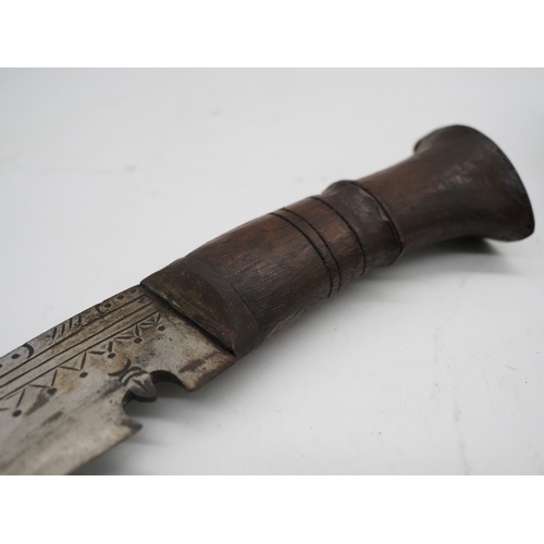 54 - Nepalese Ghurkha Knife. Carved wooden handle complete with carved wooden scabbard and single edged d... 
