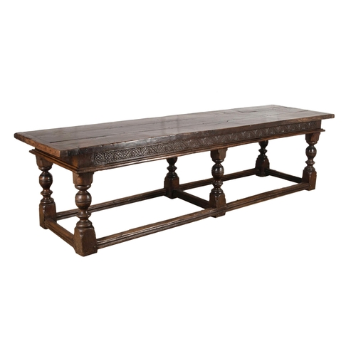 552 - Impressive 17th century style refectory table, thick oak top over a carved floral frieze and six bal... 