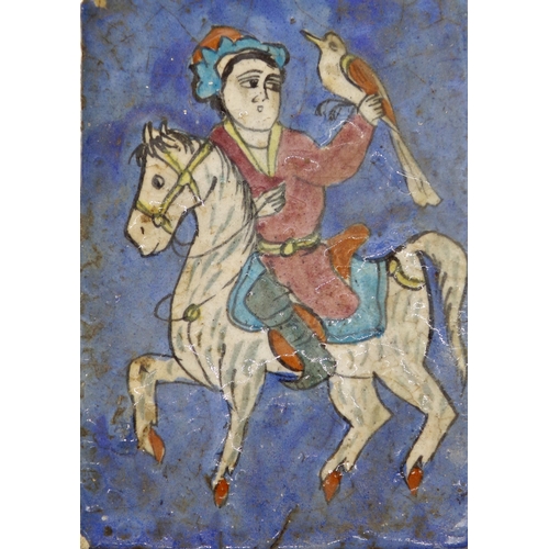 110 - Antique Persian tile decorated in relief with a falconer on horseback, 23 x 15cm