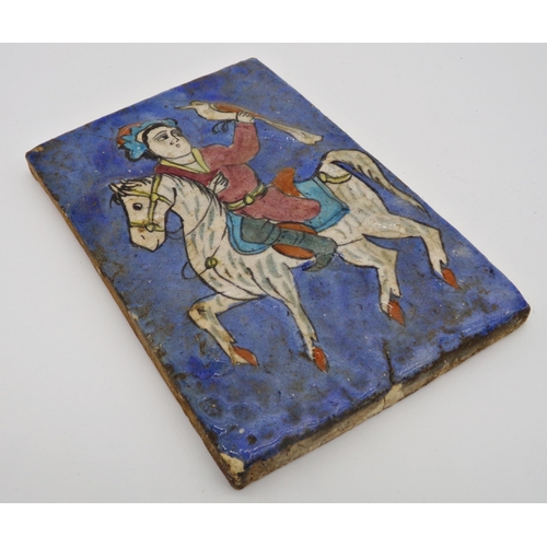 110 - Antique Persian tile decorated in relief with a falconer on horseback, 23 x 15cm