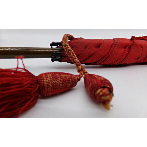 138 - Early 20th century red parasol, with finely carved horn dog head knop, 72cm long