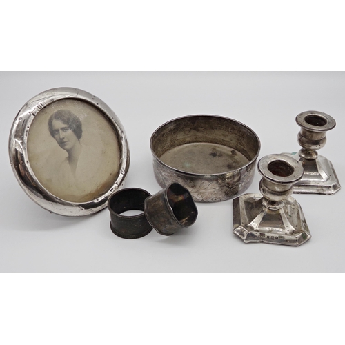 182 - Mixed silver to include pair of dwarf candlesticks, easel frame, two napkin rings and a silver plate... 