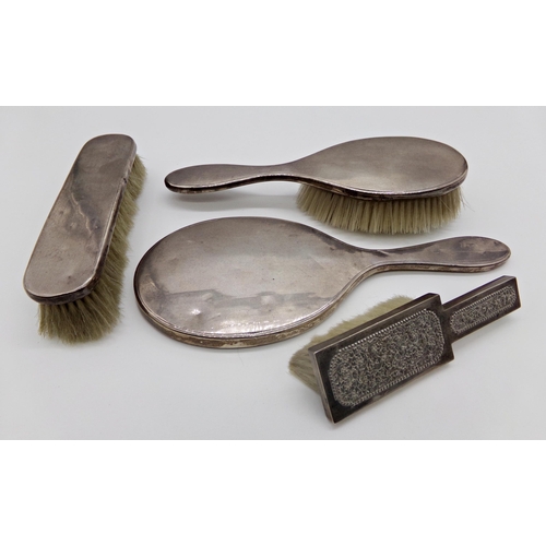 224 - Four silver dressing brushes and a dressing mirror (4)