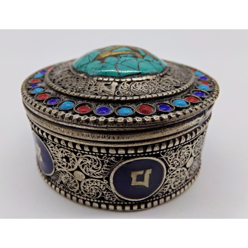 228 - Eastern filigree silver box, the top inlaid with turquoise, over a base with enamel panels, 6cm diam... 