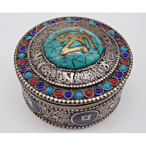 228 - Eastern filigree silver box, the top inlaid with turquoise, over a base with enamel panels, 6cm diam... 